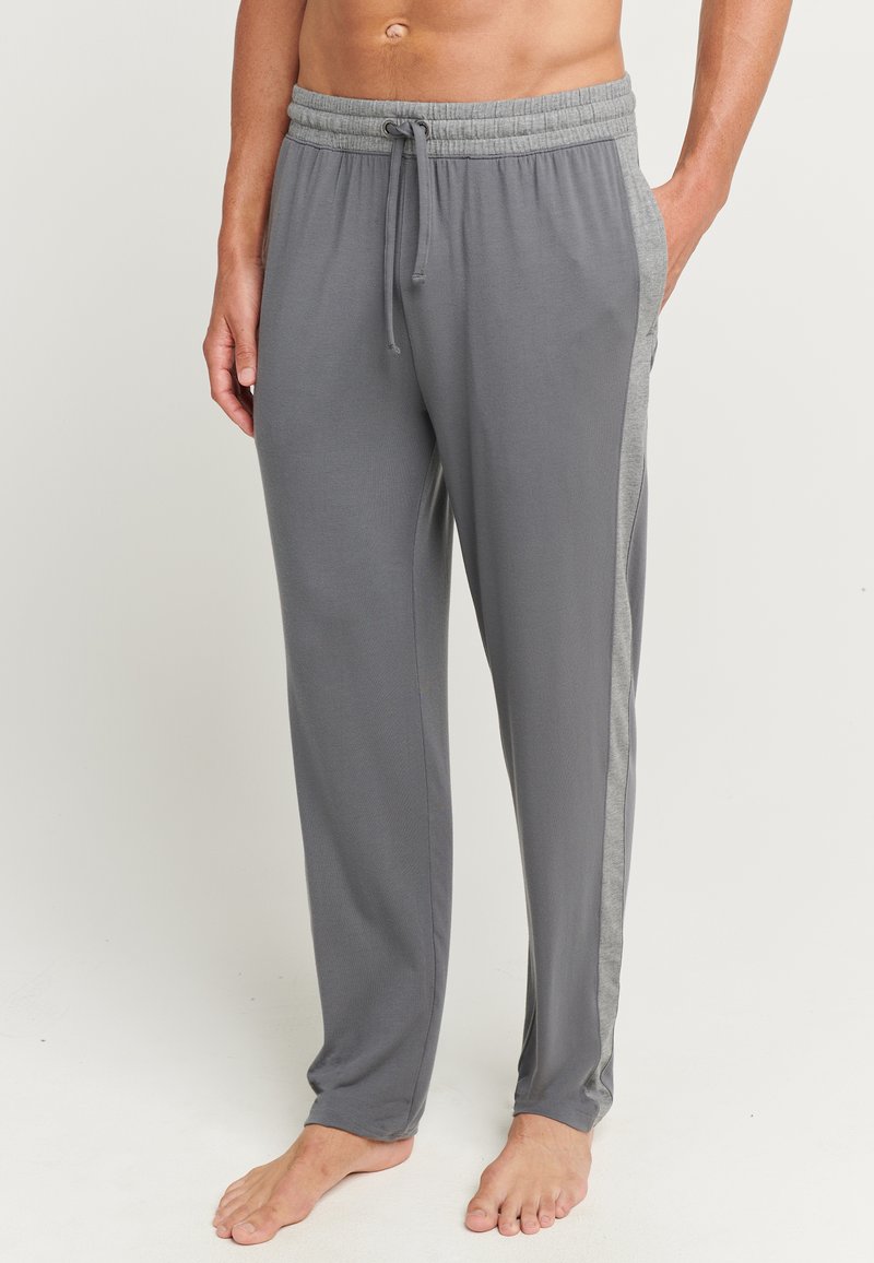 Grijze loungebroeken met een zachte geweven textuur, voorzien van een trekkoord in de taille en contrasterende lichtgrijze zijkanten. Casual pasvorm, lichtgewicht materiaal.