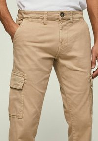 Beige cargobroek gemaakt van een katoenmix, met zijzakken, knoopsluiting, riemlussen en een rechte pasvorm.