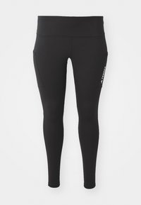 Des leggings noirs en tissu extensible, avec une taille haute, des poches latérales et un accent de logo blanc sur le côté gauche.