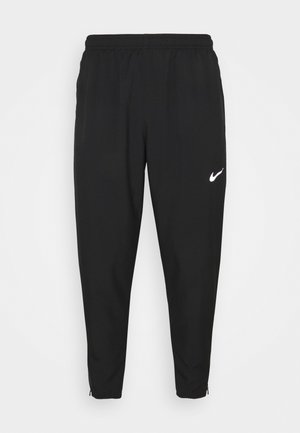 Pantaloni tuta neri Nike con vita elastica, gambe affusolate, cerniere alle caviglie e logo bianco sulla coscia sinistra. Tessuto liscio e leggero.