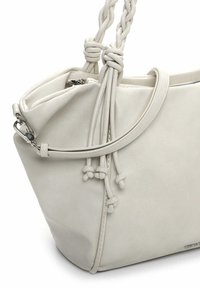 Valge nahast käekott pehme tekstuuriga, millel on punutud käepide ja nöörkinnis, kaunistatud hõbedast riistvaraga.