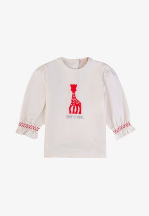 Camicia bianca in cotone a maniche lunghe con maniche a sbuffo, dotata di una grafica di una giraffa rossa e la scritta "SOPHIE LA GIRAFFE" sottostante in grigio.