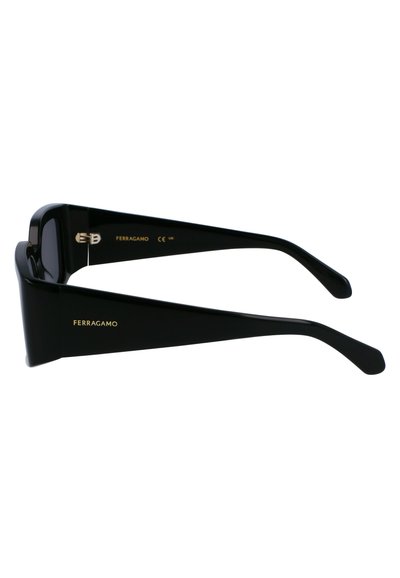 Černé sluneční brýle s silnými obroučkami, s lesklým povrchem. Stranice jsou ploché a elegantní s zlatým označením "Ferragamo" na boku.