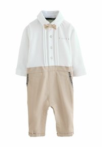 Valkoinen poolokauluksellinen paita, jossa kaulus ja rusetti, beige alaosa. Edessä nappilista ja sivutaskut, joissa kuvioidut reunukset. Valmistettu pehmeästä kankaasta.