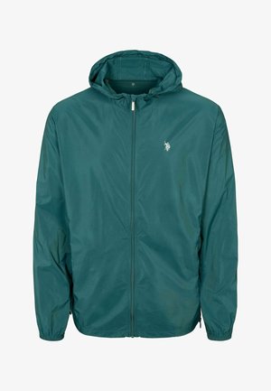 Turkusowa kurtka przeciwwiatrowa z kapturem, z pełnym zamkiem, elastycznymi mankietami i małym logo na klatce piersiowej. Lekka, gładka tekstura i casualowy design.