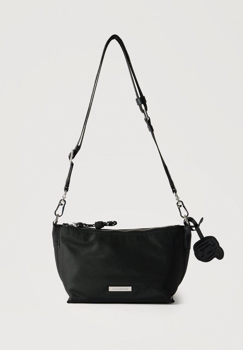 Μαύρη τσάντα ώμου από νάιλον με ρυθμιζόμενο λουράκι, κλείσιμο με φερμουάρ και λογότυπο-γούρι στο πλάι.