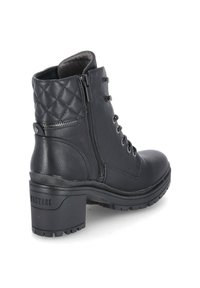 Bottine noire en cuir avec dos matelassé, fermeture éclair latérale, laçage devant, talon épais et semelle robuste avec le label Mustang.