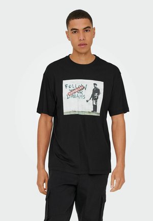 Black cotton t-shirt featuring a graphic of a graffiti art style design with text “Follow Your Dreams” crossed out and the word "CANCELLED."