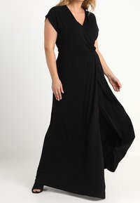 Czarna maxi sukienka z głębokim dekoltem w kształcie V, krótkimi rękawami i elastycznym pasem. Posiada rozcięcie po boku oraz swobodny materiał dla łatwości ruchu.