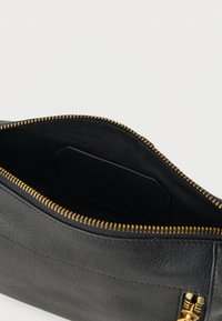 Μαύρο δερμάτινο τσαντάκι με υφή στην επιφάνεια, χρυστό φερμουάρ και λείο εσωτερικό. Διαθέτει θήκη για κάρτες στο εσωτερικό.