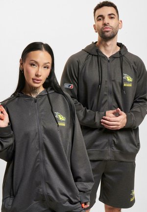 Mørkegrå zip-up hettegensere med frontlommer og brodert drage-logo. Mykt stoff og avslappet passform; kombinert med matchende shorts.