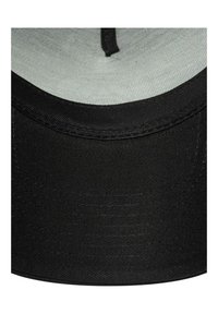 Czarna tkanina daszka czapki z detalicznym szwem, ukazująca teksturowaną powierzchnię i zakrzywioną krawędź.