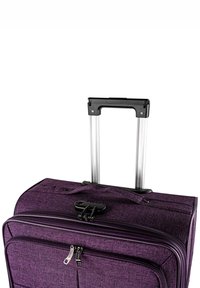 Maleta morada con ruedas, fabricada con tela texturizada, doble cremallera, cerradura de plástico negro y asa telescópica de metal.