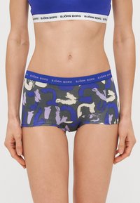 Ανδρικά μποξεράκια με λευκή ελαστική ζώνη με λογότυπο, μαύρο ύφασμα διακοσμημένο με μοβ και κρεμ αφηρημένα μοτίβα πινελιών.