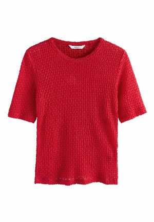 Red short-sleeve top made of textured knit fabric with a crew neckline. Features a loose fit and open weave pattern throughout.