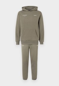 Conjunto de sweatshirt e calças de fato em verde oliva. O capuz tem um bolso frontal e detalhes em texto branco. Tecido suave, corte descontraído e punhos canelados.