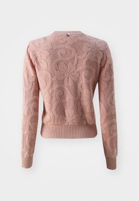 Pull rose texturé avec motifs floraux, poignets et ourlet côtelés. Présente un col rond et un détail de bouton au dos.