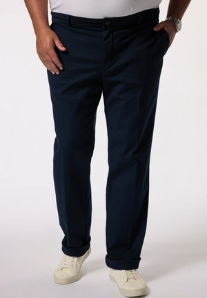 Navy blue pants made of smooth fabric, featuring a standard waistband, side pockets, and a straight-leg cut, paired with white sneakers.