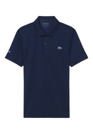 Polo Lacoste azul marino con cuello, tres botones y pequeño logo de cocodrilo verde en el pecho izquierdo.