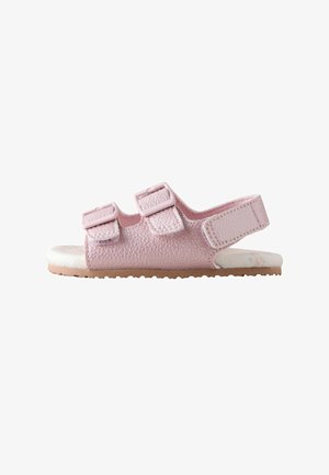 Lyserøde sandaler med tekstureret materiale, to justerbare remme og en gummisål. Sålens inderside har et blomsterprint.