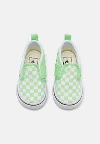 Zapatos de lona a rayas verdes y blancas, con cuello acolchado y suela flexible, que cuentan con una correa de gancho y bucle para ponérselos fácilmente.