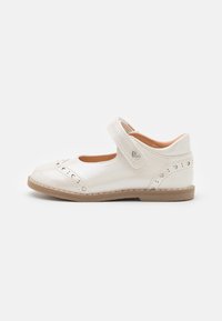 Zapato Mary Jane de charol blanco con punta redonda, detalles perforados, correa ajustable y suela de goma plana.