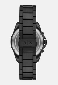 Črno nerjaveče jekleno uro s elegantnim paščkom in teksturiranimi povezavami. Ima okroglo ohišje in gravirano logotip "A|X" na sponki.