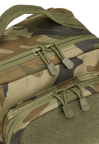 Több zsebes, álcázott hátizsák, dupla zöld cipzárral, texturált nylon és szövet keverékéből készült. Tartós varrásokkal és ergonómikus fogantyúkkal rendelkezik.