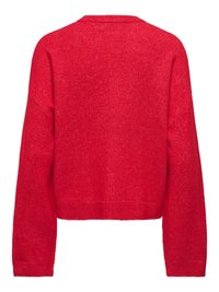 Pull rouge tricoté avec un design court, des épaules tombantes et une finition texturée. Aucun élément métallique ni ornement visible.