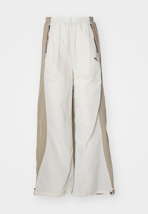 White and tan lightweight pants with a textured finish, featuring an elastic waistband, side pockets, and a small black logo.
