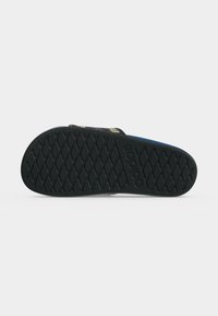 Μαύρο σανδάλι Adidas slide με σχεδιασμένη σόλα και κείμενο "adidas" ανάγλυφο στο κάτω μέρος, εμφανίζεται από την πλευρά της σόλας σε λευκό φόντο.