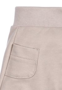 Lichtbeige sweatpants met een geribde tailleband, voorzien van een enkele open patchzak aan de zijkant en een zachte, gladde textuur.