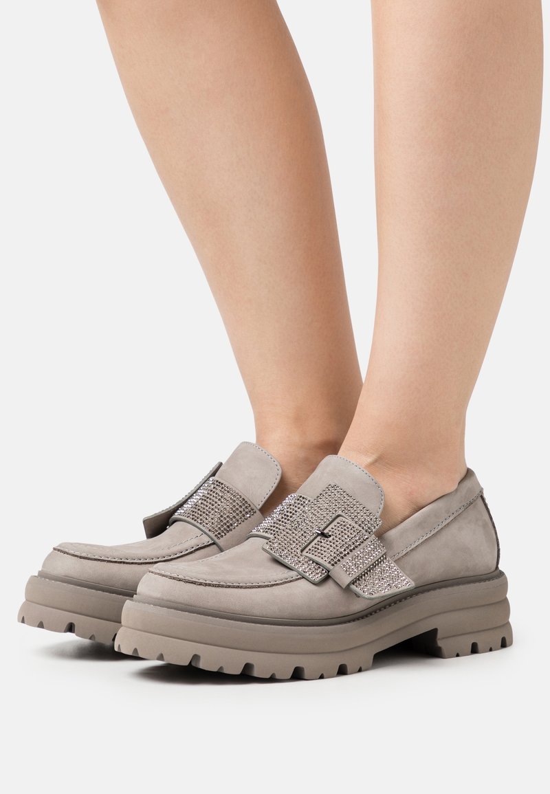 Mocassini in suede grigi con una cintura testurizzata decorata da strass, suola in gomma spessa e un design aerodinamico per comfort e stabilità.