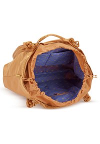 Sac polochon beige avec ouverture sur le dessus révélant une doublure intérieure bleue avec des lettres jaunes et une petite poche zippée à l’intérieur.