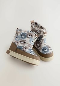 Gemusterte Kleinkinderstiefel mit Bärenmotiven in Grau, Braun und Creme. Hergestellt aus weichem Material mit einer strukturierten, massiven braunen Sohle.
