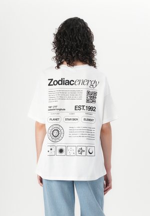 White cotton t-shirt featuring black graphics, including zodiac symbols, a QR code, and text detailing astrology elements on the back.