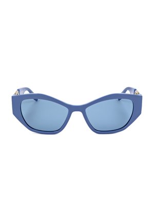 Occhiali da sole oversize azzurri a forma di cat-eye con montature spesse e lenti scure su sfondo bianco.