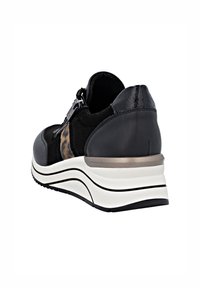 Schwarzer Sneaker mit einem Design aus gemischten Materialien, das glattes Leder und Wildleder kombiniert, einen metallischen Akzent aufweist und eine gepolsterte weiße Sohle hat.
