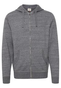 Sudadera con cremallera gris hecha de una tela suave, con capucha, dos bolsillos frontales y puños y dobladillo acanalados. Diseño simple y texturizado.