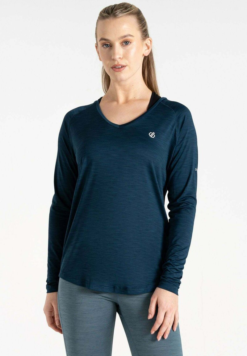 Dunkelblaues langärmliges Sportshirt mit V-Ausschnitt. Besitzt einen strukturierten Stoff und ein kleines Logo auf der Brust. Kombiniert mit grauen Leggings.