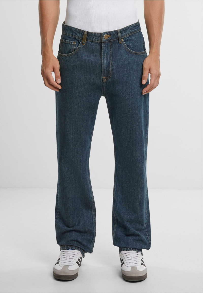 Jeans in denim blu scuro con una vestibilità a gamba dritta, dotati di cinque tasche, chiusura con bottone metallico e dettagli di cucitura visibili.