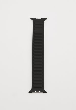 Cinturino in silicone nero con scanalature testurizzate, bordi lisci e hardware in argento a entrambe le estremità per l'aggancio.
