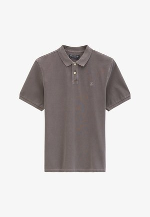 Braunes Poloshirt mit kurzen Ärmeln, Kragen, zwei beigen Knöpfen und kleinem "M OP" Logo auf der linken Brustseite.
