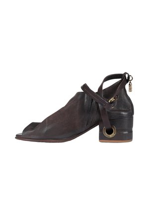 Scarpa aperta in pelle marrone scuro con tacco basso a blocchetto, cinturino alla caviglia con anello metallico e cerniera con targhetta incisa sul retro.