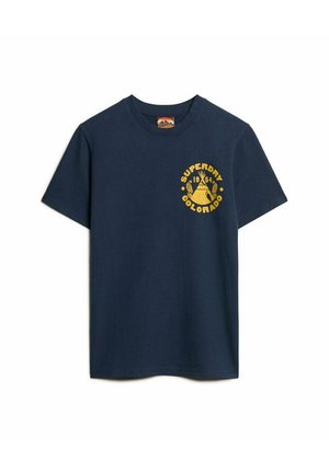 Camiseta de algodón azul marino con manga corta, con un escote redondo y un logo circular amarillo con texto en la parte frontal.