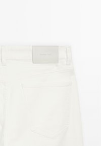 Jeans in denim bianco con etichetta in pelle grigia rettangolare con la scritta "Massimo Dutti" in rilievo, tasca posteriore singola con dettagli di cucitura.