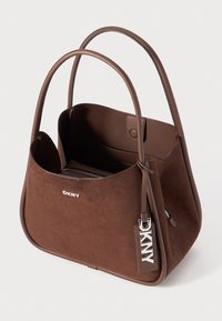 Borsa tote in pelle marrone con texture in morbido suede, forma arrotondata, doppi manici e logo argentato. Presenta una tasca interna con zip.