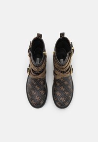 Czarne botki za kostkę z teksturowaną, wzorzystą cholewką, zdobioną złotymi akcentami i dekoracyjnymi klamrami. Okrągły czubek i solidna podeszwa.