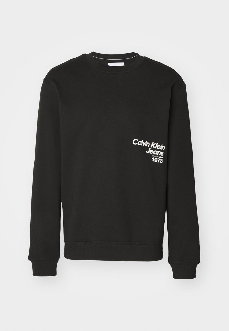 Sweat-shirt en coton noir à manches longues avec poignets côtelés. Présente un texte blanc : "Calvin Klein Jeans" et "1978" sur la poitrine.