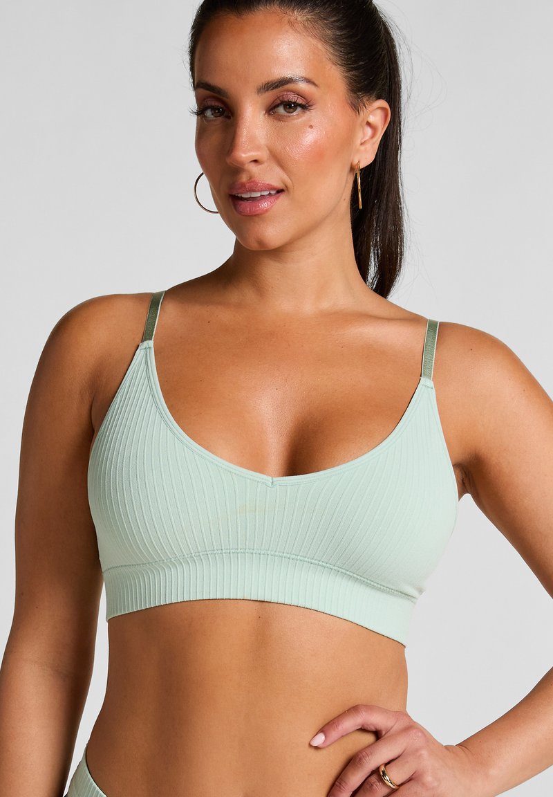 Lichtgroene geribbelde bralette met dunne verstelbare bandjes en een gladde band. Het naadloze ontwerp accentueert de pasvorm en biedt comfort.